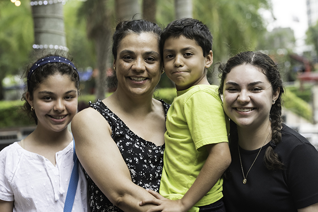 Smiling Hispanic mature woman posing with her children