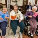 assisted living residents hold handmade cards