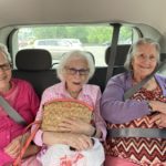 three resident women smiling while in car