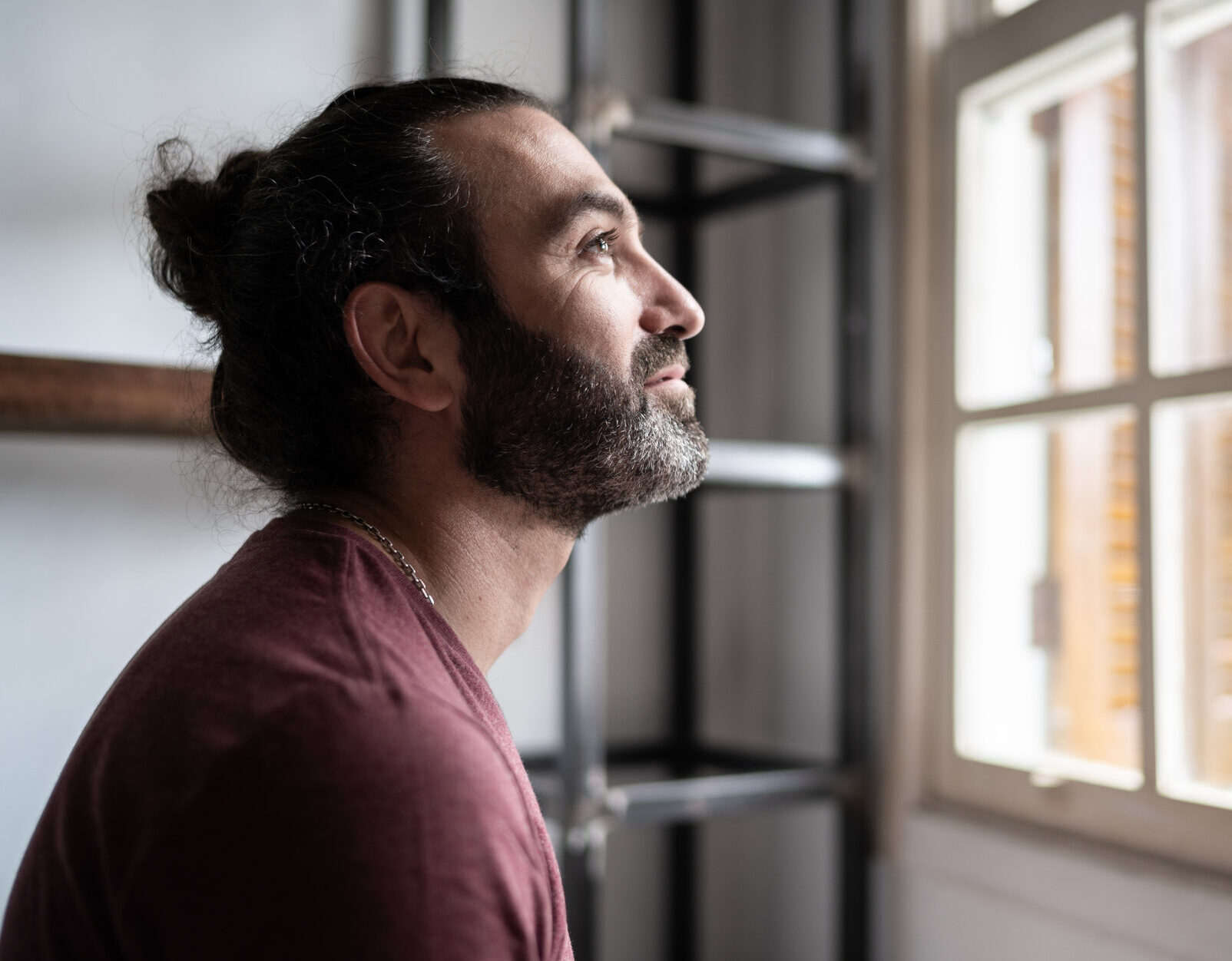 Man looking through the window at home